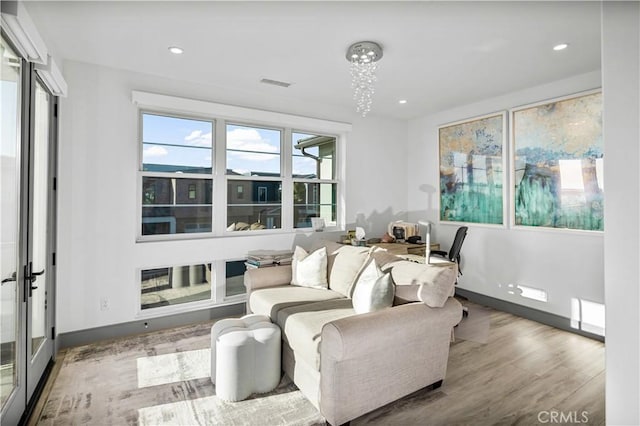 living area with an inviting chandelier and light wood-type flooring