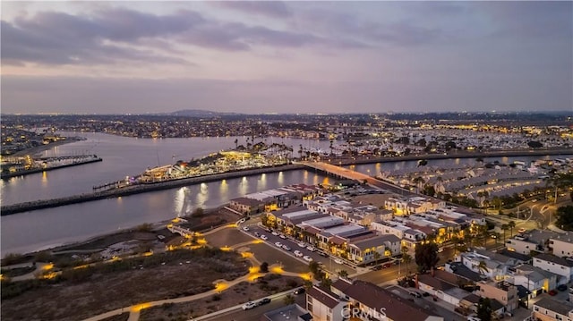 aerial view at dusk featuring a water view