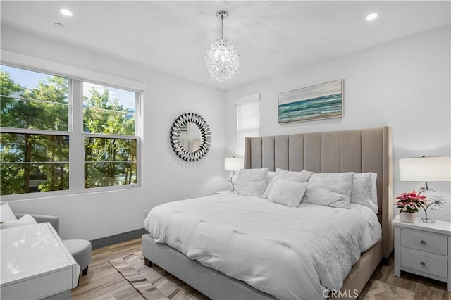 bedroom featuring a notable chandelier and light wood-type flooring