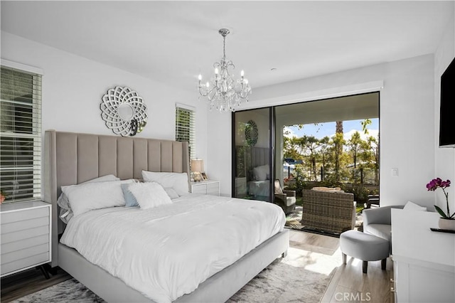 bedroom featuring an inviting chandelier, access to exterior, and hardwood / wood-style floors