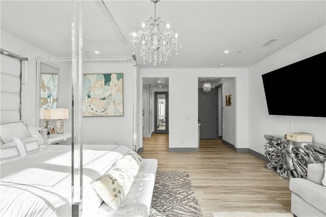 bedroom featuring a chandelier and light hardwood / wood-style flooring