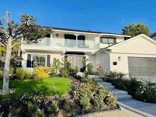 view of front of property featuring a front lawn and a garage