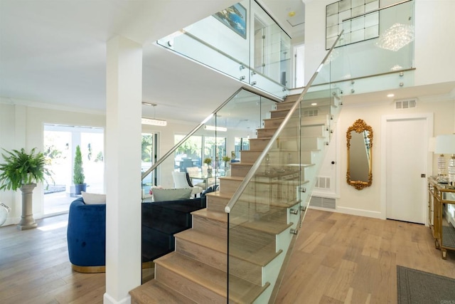 staircase featuring ornamental molding and wood-type flooring