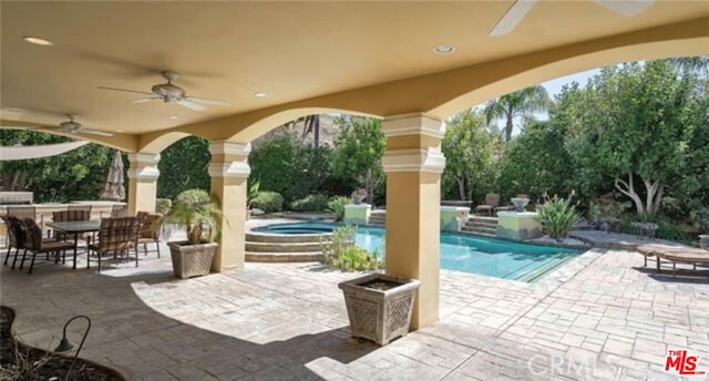 view of patio / terrace featuring ceiling fan and a swimming pool with hot tub