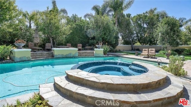 view of pool with a patio area and an in ground hot tub