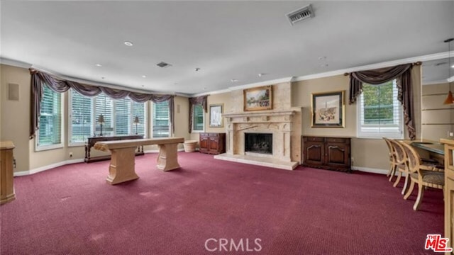 rec room with a premium fireplace, ornamental molding, and carpet floors