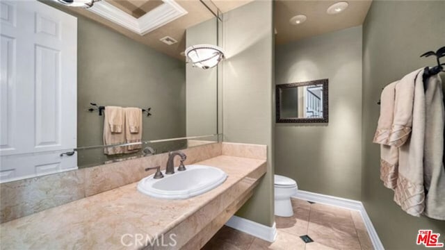 bathroom featuring toilet, tile patterned flooring, and sink