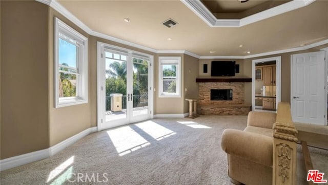 carpeted living room featuring ornamental molding, french doors, and a fireplace