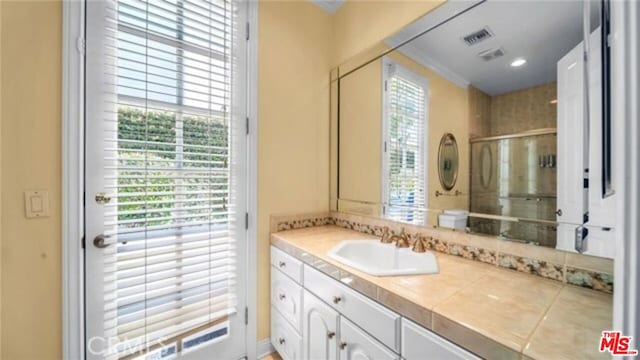 bathroom featuring walk in shower and vanity