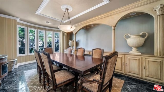 dining area with a tray ceiling and ornamental molding