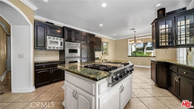 kitchen with white cabinets, stainless steel appliances, tasteful backsplash, light tile patterned flooring, and crown molding