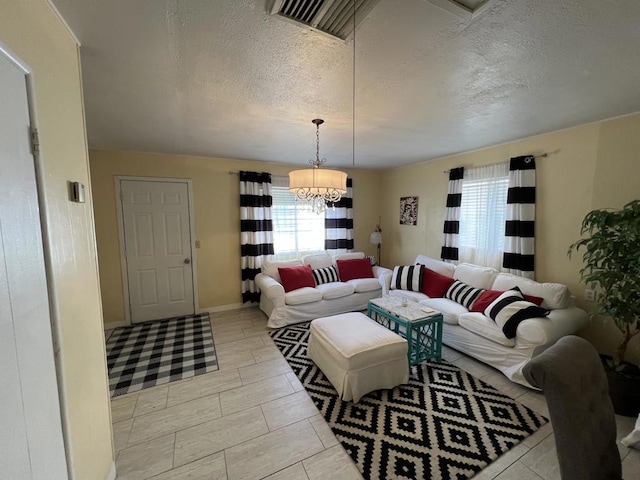 tiled living room with an inviting chandelier and a textured ceiling