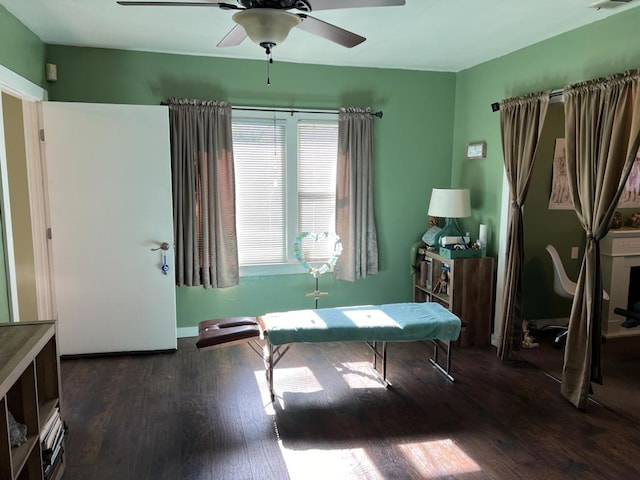 sitting room with dark wood-type flooring and ceiling fan