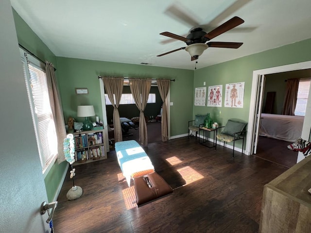 living room with dark hardwood / wood-style flooring and ceiling fan