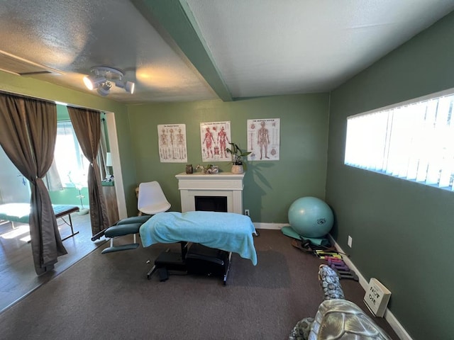 bedroom featuring beamed ceiling and a fireplace