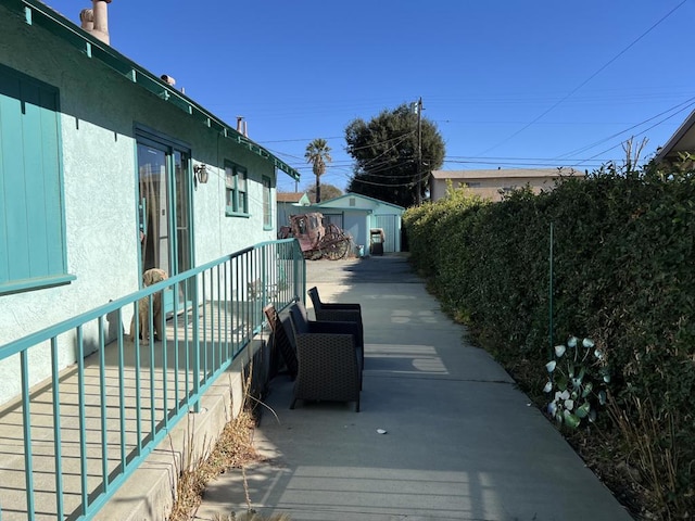 view of home's exterior with a patio area and a storage unit