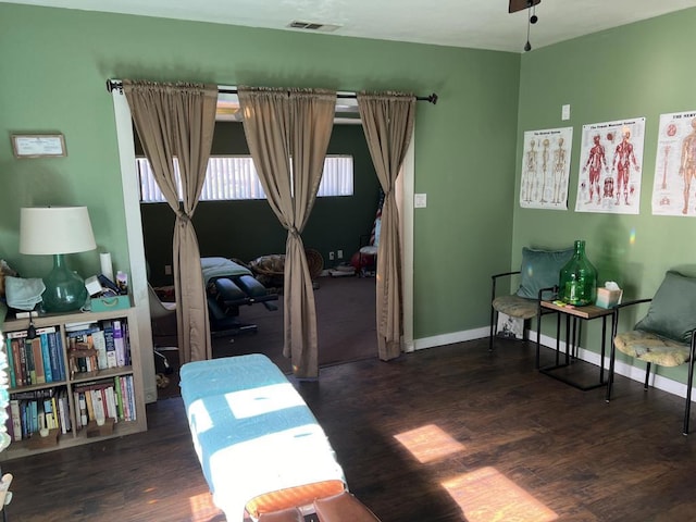 living area with dark wood-type flooring and ceiling fan