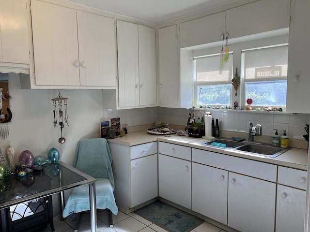 kitchen with white cabinetry, sink, decorative backsplash, and light tile patterned floors