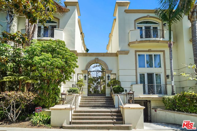 view of exterior entry featuring a balcony