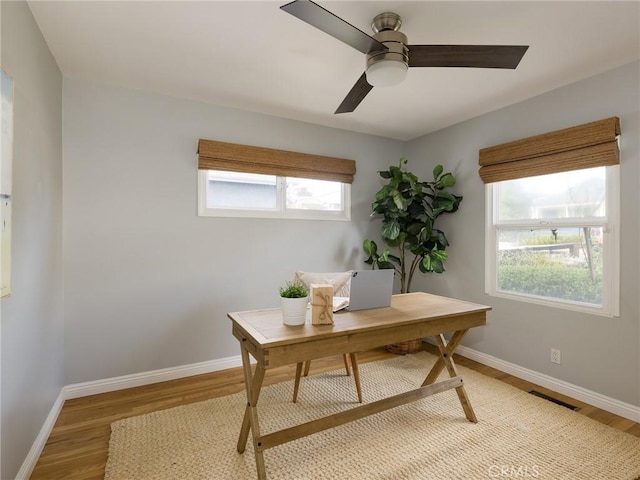 home office with ceiling fan and light wood-type flooring