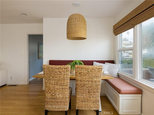 dining space with breakfast area, radiator, and hardwood / wood-style floors