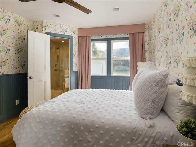 bedroom featuring wood-type flooring, ceiling fan, and ensuite bath