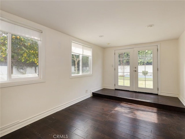 spare room with dark wood-type flooring and french doors