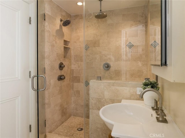 bathroom with sink and an enclosed shower