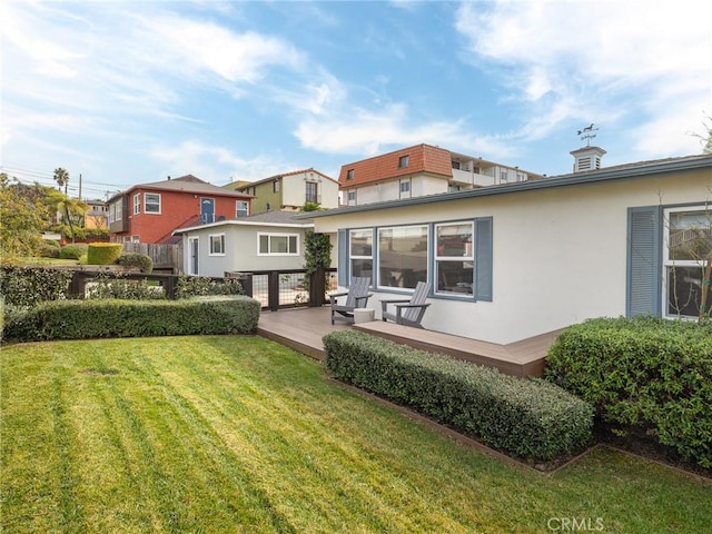 rear view of property with a yard and a deck