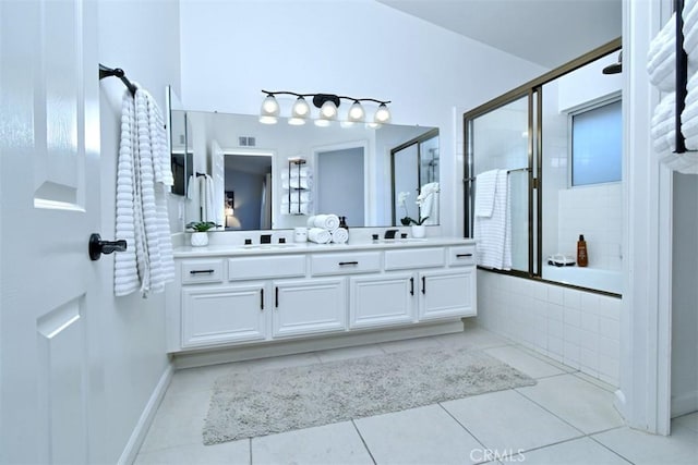 bathroom with vanity, tile patterned flooring, and bath / shower combo with glass door