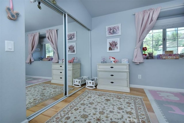 bedroom featuring multiple windows, a closet, and hardwood / wood-style floors