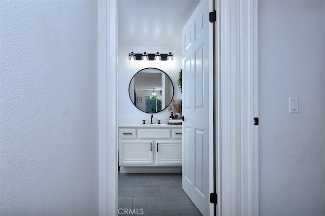 hallway featuring dark tile patterned flooring and sink