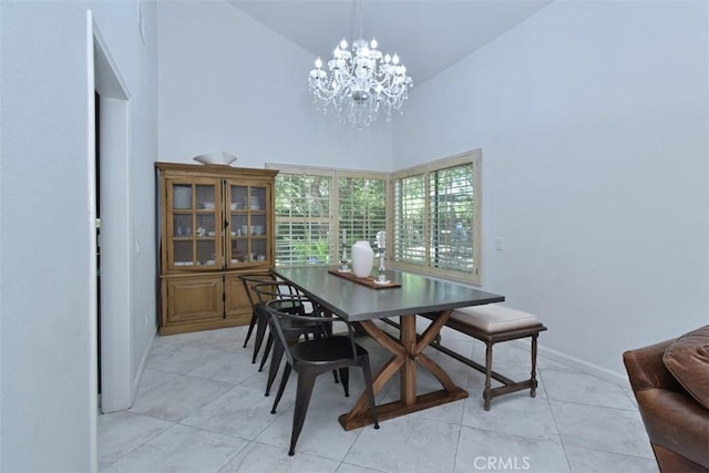 tiled dining area featuring high vaulted ceiling and an inviting chandelier