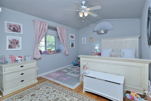 bedroom featuring ceiling fan, light hardwood / wood-style flooring, and lofted ceiling