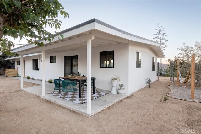 back house at dusk with a patio