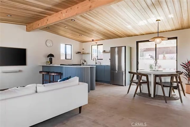 living room featuring concrete flooring and lofted ceiling with beams