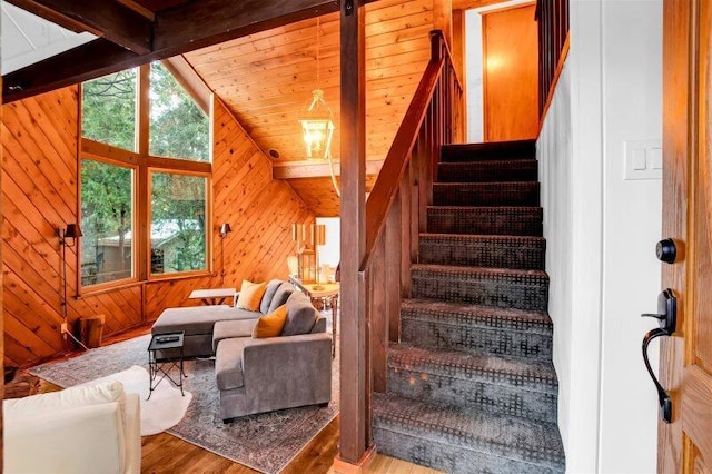 staircase with wooden ceiling, hardwood / wood-style floors, and wood walls