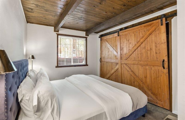 bedroom with a barn door, beamed ceiling, and wooden ceiling