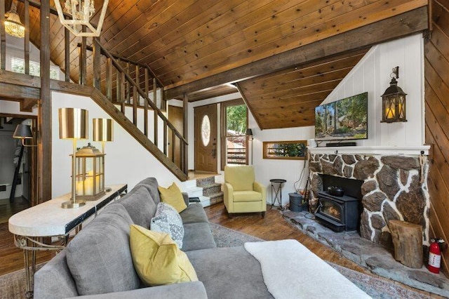 living room with lofted ceiling, wood ceiling, dark hardwood / wood-style flooring, wooden walls, and a wood stove