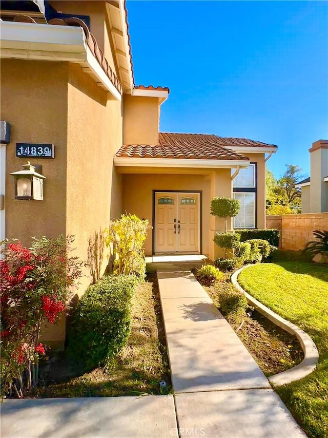 view of exterior entry with a yard