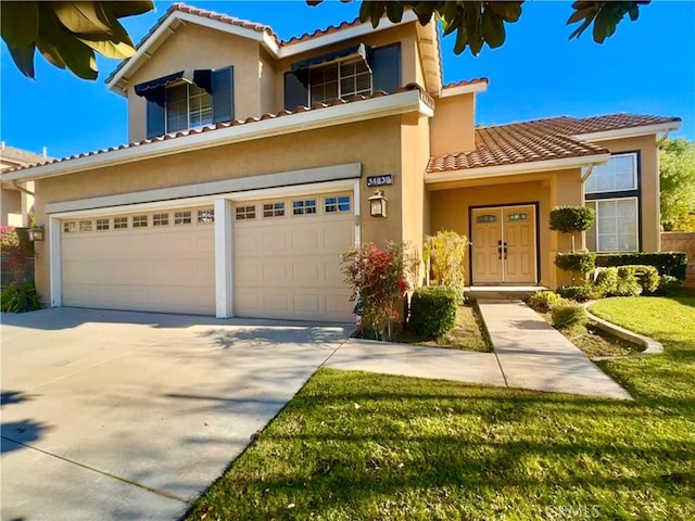 mediterranean / spanish-style home featuring a garage and a front yard