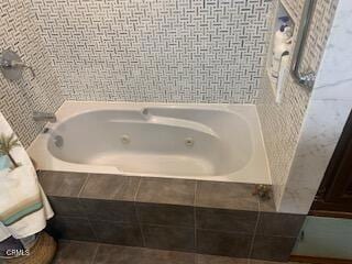 bathroom with tile patterned floors and tiled tub