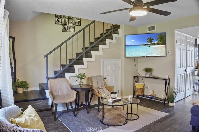 living room featuring ceiling fan and dark hardwood / wood-style floors