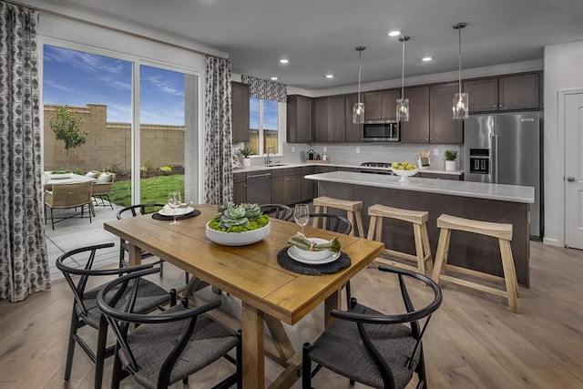 dining space with light hardwood / wood-style floors and sink