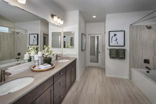 bathroom featuring tiled shower / bath and vanity