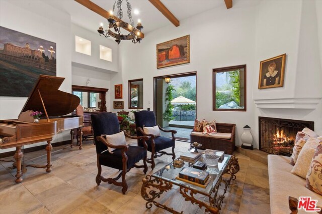 sitting room with a towering ceiling, an inviting chandelier, and beam ceiling