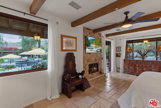 bedroom featuring beam ceiling, access to exterior, ceiling fan, and a fireplace