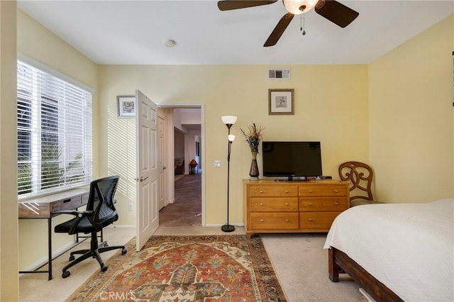 carpeted bedroom with ceiling fan and multiple windows