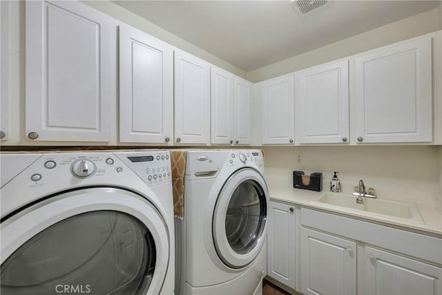 washroom with washer and clothes dryer, sink, and cabinets