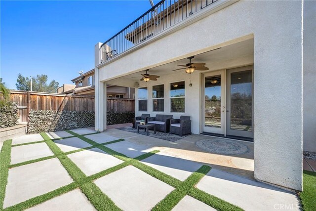 view of patio / terrace featuring ceiling fan, french doors, and a balcony